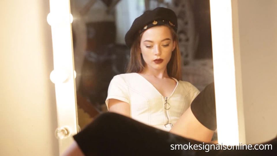 Kyra smoking in front ao a mirror.